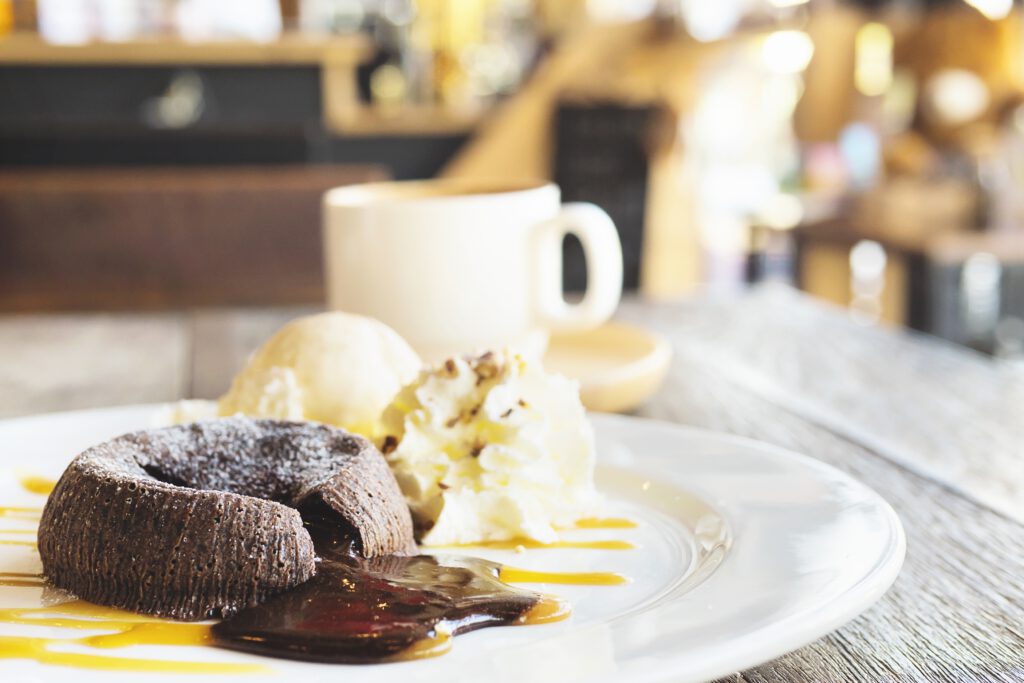chocolate lava cake with vanilla ice cream and coffee cup in background