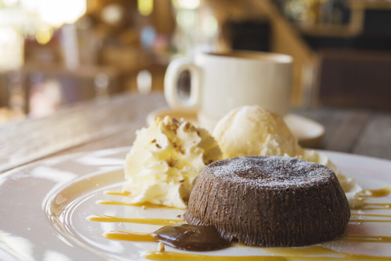 chocolate lava cake with vanilla ice cream and coffee cup in background